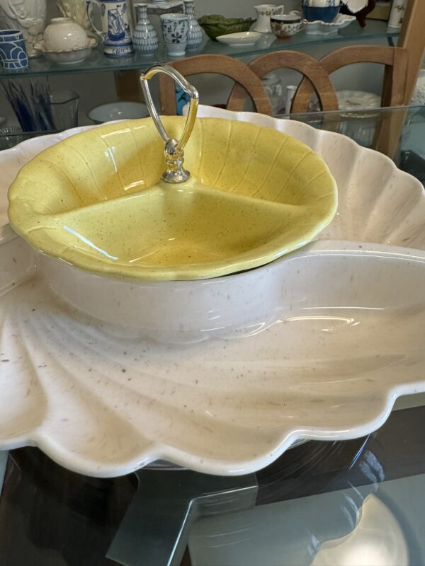The Lane & Co. MCM Serving Set features a large, pale pink ceramic shell-shaped dish and a smaller yellow shell bowl with a metal handle—an eye-catching addition to any mid-century modern decor.