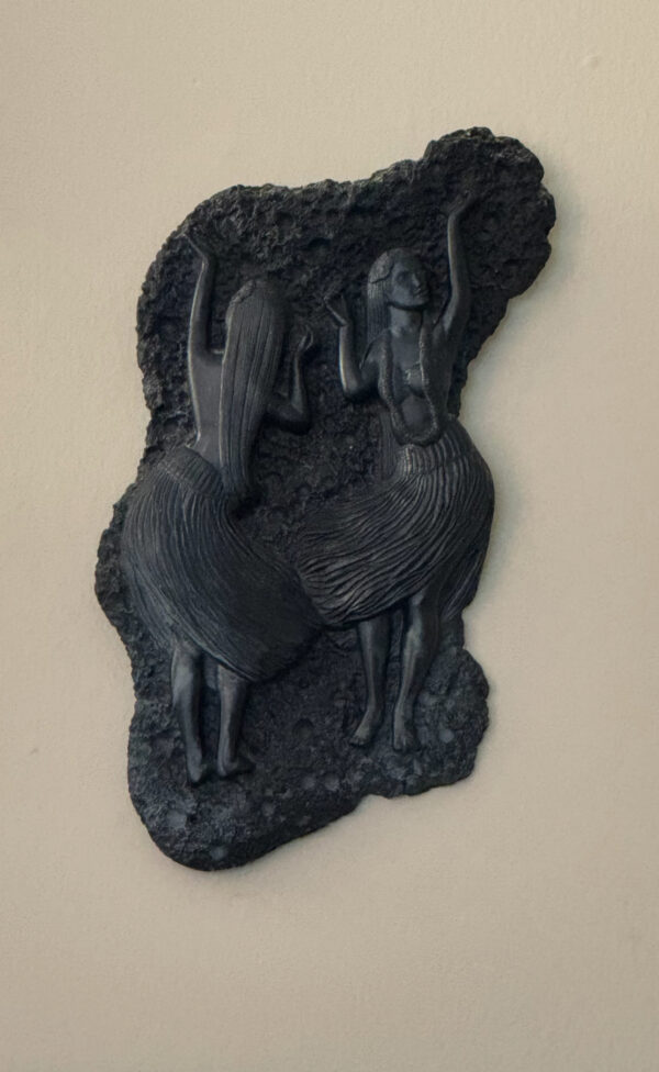 The Coco Joe's Hawaii Wall Hanging features two women in grass skirts dancing with arms raised, their long hair and flowing skirts finely detailed on a dark, textured, irregular piece that captures the lively spirit of Hawaii.