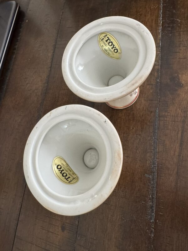 Two white ceramic bowls with rounded bottoms and gold “Toyo Japan” stickers inside are placed on a wooden surface. The bowls appear vintage and are viewed from above at an angle, showing the glossy interior and sticker details.