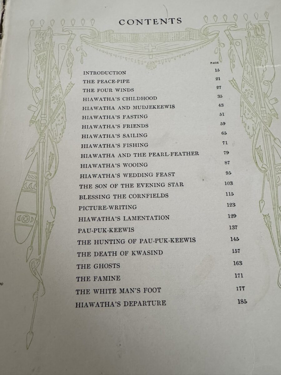 A book’s table of contents page features an ornate green border with Native American motifs. Chapter titles and page numbers are listed, including “The Peace-Pipe,” “Hiawatha’s Fasting,” and “The Ghosts.” The page background is off-white.
