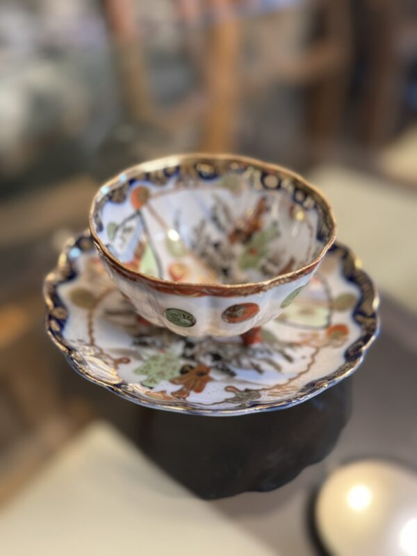 The Woulind Chile Serving Dish showcases traditional floral and nature motifs in intricate, colorful patterns with gold trim, resembling a porcelain teacup set on a matching saucer for elegant table presentations.