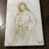 The Woulind Chile Serving Dish is a rectangular marble piece featuring a sepia-toned sketch of a woman in a long dress holding white flowers, with "Ingrid" inscribed in the lower right corner. It is displayed on a dark wooden surface.