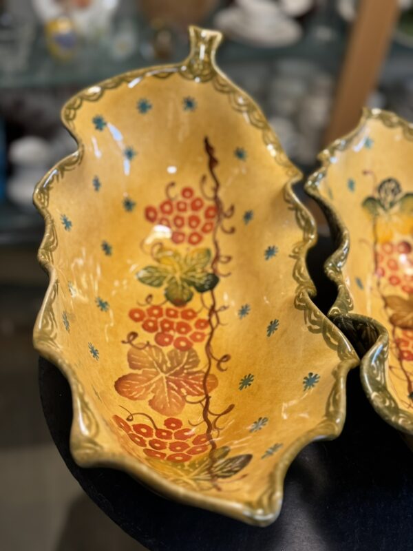 Italian Oblong MCM Serving Dishes feature wavy, uneven edges, glossy yellow glaze, red berries, green leaves, brown stems, blue floral accents inside, and a green-outlined rim. Another serving dish is partly visible beside it.