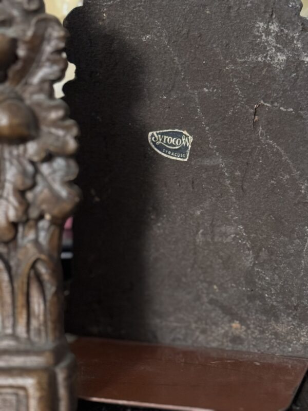 A close-up shows an ornate carved wooden piece next to a worn metal plate labeled