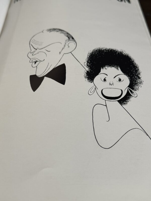 A minimalist black-and-white line drawing shows two people: an older bald man in a bow tie singing passionately on the left, and a woman with a round afro, large earrings, wide eyes, and an open mouth on the right. Both have expressive faces.