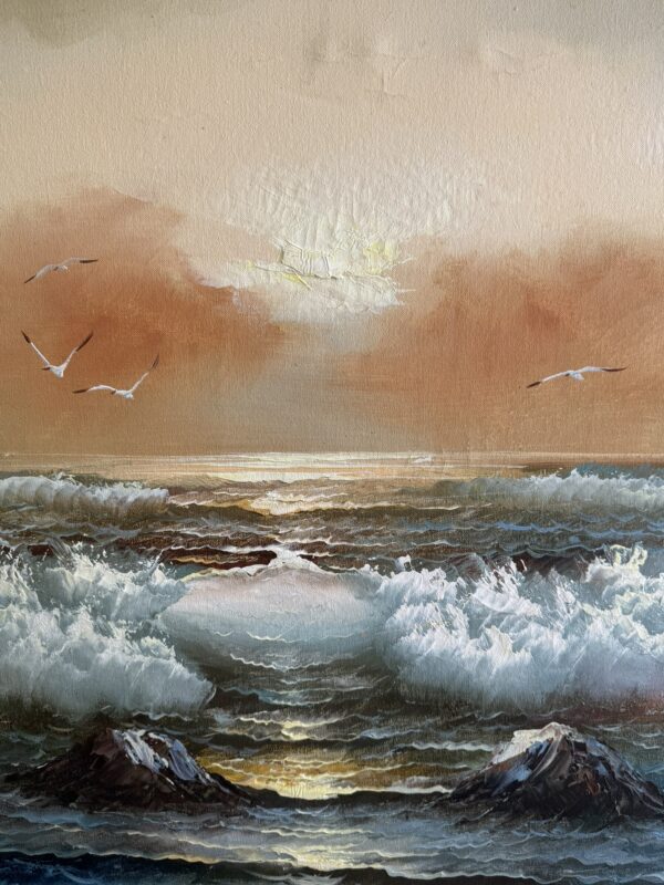 A seascape painting depicts crashing waves under a warm orange sky at sunset. Four seagulls soar above the water, with sunlight glinting off the sea. Rocky outcrops emerge from the surf in the foreground, while wispy clouds float near the horizon.