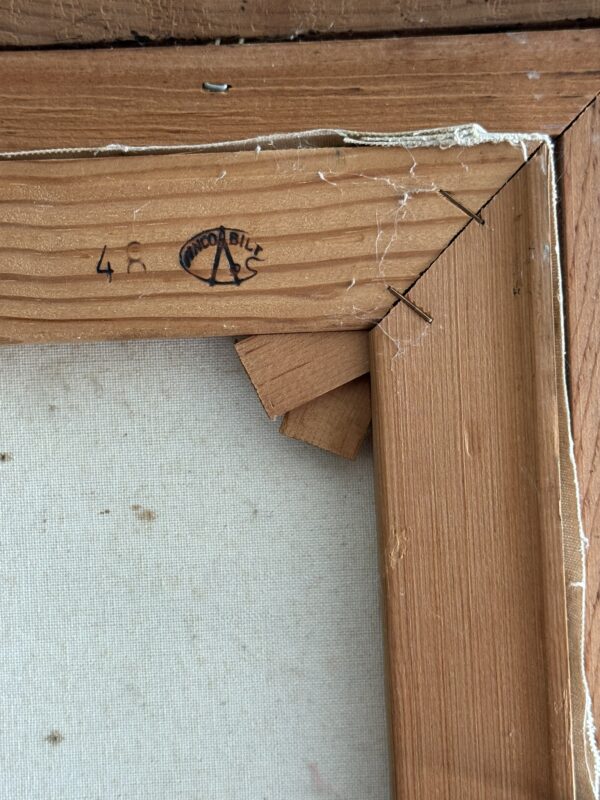 Close-up of the back corner of a wooden picture frame, showing overlapping wood pieces, corner joints, wood grain, and a small wood splinter. A stamp reading “AMCO BILL” with an “A” logo and the number 48 appears on the wood. Some cobwebs are visible.